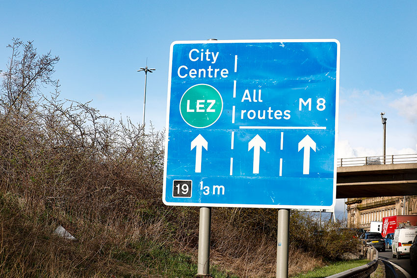 LEZ road sign with trees and blue sky in the background