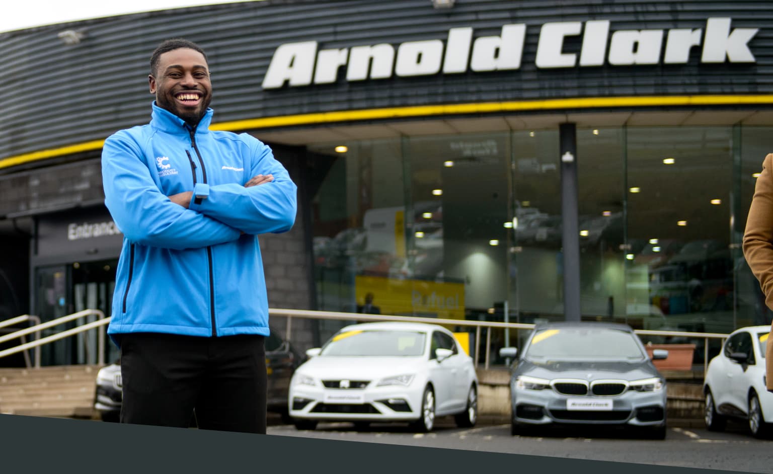 Product Consultant standing outside of an Arnold Clark branch